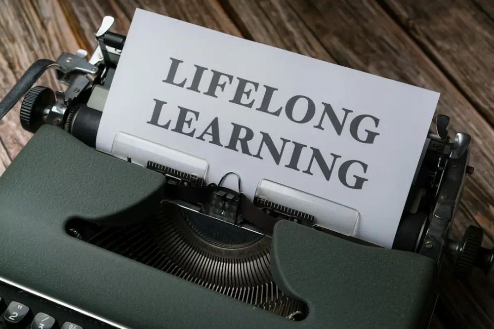 A close up of a typewriter with a paper that says lifelong learning, illustrating learning foundations